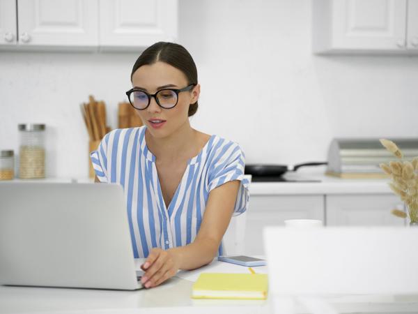 Woman working on laptop in kitchen