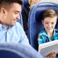 Father and son using tablet on bus
