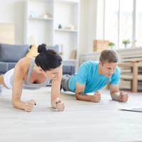 Couple doing plank exercise at home