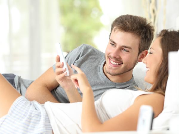 Happy couple using smartphone