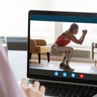 Woman using laptop for online fitness workout