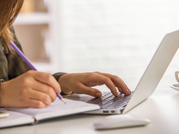 Student taking notes on laptop