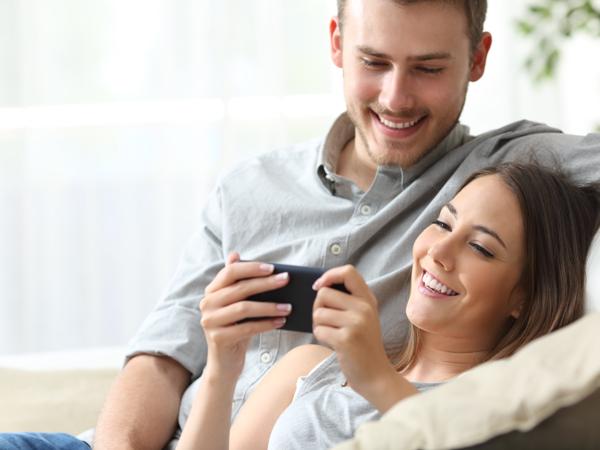 Happy couple using smartphone app