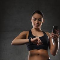 Woman using fitness tracker in gym